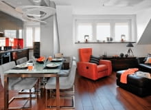 Pani Joanna pokochała swoje niewielkie mieszkanie jeszcze zanim się okazało, że można wykupić i zaadaptować poddasze. Dlaczego? Bo idealnie pasowało do koncepcji wystroju, jaką od dawna miała i którą zaakceptowała projektantka. W efekcie ulubione materiały wykończeniowe obu pań, czyli stal i beton, przemieniły tradycyjne wnętrze w nowoczesne, o modnym industrialnym charakterze. <BR /> MIESZKANIE. W otwartej części dziennej nowoczesna kuchnia kontrastuje z tradycyjnie urządzonym kącikiem wypoczynkowym, w którym ton narzuca fotel w mocnym pomarańczowym obiciu. Na podłodze w kuchni i przedpokoju położono terakotę, w części wypoczynkowej są deski z egzotycznego drewna doussie. Nad stołem zwiesza się efektowna lampa.