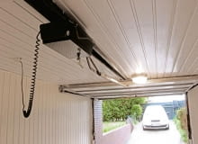 Napęd uchylnej bramy garażowej zamontowany pod sufitem garażu napęd do bramy garażowej