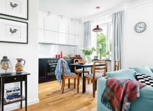 ŚCIANĘ NAD BLATEM KUCHENNYM chroni tafla hartowanego szkła w takim samym kolorze jak wiszące szafki. Na podłodze leżą olejowane dębowe deski; listwy przypodłogowe są zrobione z polakierowanej na biało płyty MDF.