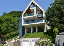 Dom jest wsparty na czterech smukłych, blisko dziesięciometrowych kolumnach i częściowo naturalnej półce w skarpie wzgórza dom jednorodzinny