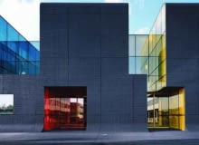 RATP Bus Center w Thias na przedmieściach Paryża projektu ECDM Architects. Monolityczny budynek przepruwają kolorowe, szklane patia kolor, paryż, szkło, fasada, beton, francja