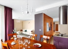 <b> RAZEM, A JEDNAK ODDZIELNIE. Wyraźny podział przestrzeni w części dziennej uzyskano dzięki zastosowaniu różnych barw, stylów i materiałów. Optyczne strefy wzmocniono, stawiając przegrody meblowe. W efekcie żaden z aneksów o odmiennych funkcjach nie koliduje ze sobą. </b> <BR /> Właścicielka mieszkania zdecydowała się na połączenie pokoju z kuchnią i przedpokojem, mimo obaw, że dwa ostatnie pomieszczenia będą dominować nad częścią salonową. Zawierzyła projektantce, która zapewniła ją, że tak się nie stanie. Kąt wypoczynkowy został oddzielony od aneksu kuchennego i od przedpokoju wysokimi ściankami, przy których zbudowano pojemne schowki. Jadalnię urządzono w obszernej wnęce niedaleko kuchni. Chociaż strefy jadalnej nie wydzielają dodatkowe przegrody, to jej odrębność jest wyraźna - podkreślają ją eleganckie stylizowane meble, które kontrastują z prostymi formami elementów wyposażenia w pozostałych częściach wnętrza. Kuchni nie widać ze strefy wypoczynkowej - zasłania ją wysoka zabudowa ze schowkami i urządzeniami AGD: piekarnikiem, kuchenką mikrofalową, ekspresem do kawy oraz lodówką i chłodziarką do wina. Strefę tę dodatkowo wyodrębnia podwieszany sufit i podłoga - płytki gresu dopasowane barwą do dębowego parkietu w salonie (gres położono też w części wejściowej przedpokoju).