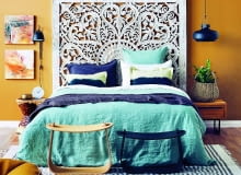 Główna ozdoba tej sypialni - efektowny zagłówek. Aby go odpowiednio wyeksponować, ścianę za nim pomalowano na kontrastowy kolor, który wydobył piękno ażurowego wzoru.