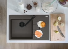 Franke zlewozmywak z czarnymi matowymi elementami i baterią.