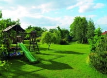 Grupy roślin ozdobnych rozmieszczono na obrzeżach trawnika. Dzięki temu dzieci mają duży teren do zabawy. A w przyszłości w miejscu zjeżdżalni, drabinki do wspinania i piaskownicy będzie można utworzyć nowe rabaty Grupy roślin ozdobnych rozmieszczono na obrzeżach trawnika. Dzięki temu dzieci mają duży teren do zabawy. A w przyszłości w miejscu zjeżdżalni, drabinki do wspinania i piaskownicy będzie można utworzyć nowe rabaty