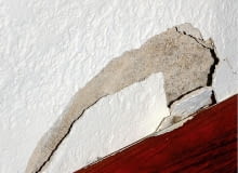 Odspojony przy listwie przypodłogowej tynk