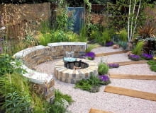 Żwirowe placyki są dobrą alternatywą dla utwardzonych nawierzchni (woda bez trudu wsiąka w ziemię) i wymagają minimum pielęgnacji Brick built rustic fire pit, crushed recycled ceramic gravel path with sleepers - 'The Fire Pit Garden' - Silver Medal Winner at the RHS Hampton Court Flower Show 2010