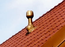 Wyrzutnia dachowa zużytego powietrza wentylacyjnego. Ten jeden mały komin zastępuje duże kominy murowane niezbędne do usuwania powietrza w domach z wentylacją grawitacyjną R