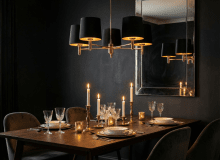 Nad stołem zawisła klasyczna lampa Ponte w eleganckim czarnym kolorze z zewnątrz i złotym w środku. Jej ciepłe światło wzmocnione zostało blaskiem świec.