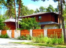 Widok na dom od strony ulicy. Uroku dodają budynkowi wysokie drzewa i położenie na skraju lasu. dom jednorodzinny