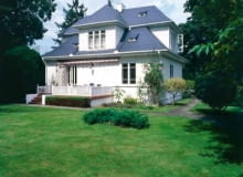 Drewniany modrzewiowy dom otoczony ogrodem utrzymanym w charakterze parku. Kilka lat temu elewację budynku pomalowano na biało, a dach pokryto łupkiem w kolorze grafitu układanym na łatach i kontrłatach przybitych do papy na deskowaniu. Drewniany modrzewiowy dom otoczony ogrodem utrzymanym w charakterze parku. Kilka lat temu elewację budynku pomalowano na biało, a dach pokryto łupkiem w kolorze grafitu układanym na łatach i kontrłatach przybitych do papy na deskowaniu.