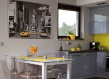 Aneks kuchenny ma wyrazistą kolorystykę - szafki są polakierowane na błękitny kolor, ściana jest jaskrawożółta. Wyraźnie odcina się więc od reszty pomieszczenia, w którym dominują szarości, biel i beże. WNETRZA JADALNIA MEBLE