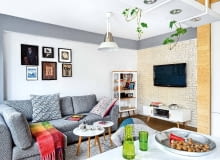 STONOWANE BARWY. W całym mieszkaniu dominują spokojne beże, biele i szarości, żywsze kolory występują tylko w dodatkach. W ścianie, na której wisi dziś telewizor, była niepraktyczna wnęka. Architektka zlikwidowała ją (powiększając dzięki temu garderobę), a nowo postawioną ścianę wyłożyła płytkami imitującymi cegłę (sklep Bartico). Pod sufitem zaprojektowała ramę z płyty gipsowo-kartonowej, w której zamontowano oświetlenie punktowe. Kanapa jest ze sklepu Agata, dywanik z decoretro.com.pl Obrazy na ścianie Beata przywiozła z egzotycznych podróży. Na przykład akcenty orientalne wiążą się z wyprawą do Chin, gdzie organizowała festiwal 'Polskie Kręgi Sztuki'.