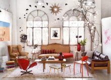 Ludwikowska sofa tapicerowana lnem, stary fotel obity jutowym workiem, reinterpretacja słynnego obrotowego krzesła Swan Arne Jacobsena, wykonana z beczek po benzynie przez firmę PO!Paris. Między oknami zdjęcie malijskiego fotografa Seydou Keity. dom