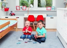 Na podłodze leży szary dywan, który pozostał z poprzedniego wystroju. Jest miękki i ciepły, chłopcy mogą się więc na nim bawić. W drugiej części pokoju pojawił się dekoracyjny dywanik z motywem ulic.