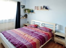 Sypialnia jakich wiele. Centralnie ustawione łóżko z szafkami nocnymi po bokach, a na ścianach pomalowanych na chłodny błękit - półeczki na książki i drobiazgi. Jest tu wszystko, co potrzebne do wypoczynku. Prócz nastrojowej atmosfery.