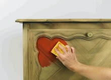 Malowanie komody. Po oczyszczeniu komody papierem ściernym i odpyleniu nanosimy wzdłuż słojów gąbką bejcę (tu kolor mak). Nada ona drewnu barwę, ale nie zakryje rysunku słojów. malowanie mebli z płyty