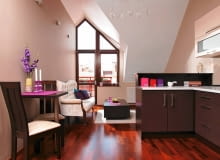 To pierwsze własne mieszkanie pani Wioletty. Wyczekiwane i wymarzone, dlatego w jego aranżację włożyła mnóstwo serca. Kierowała się jednak również rozsądkiem - żeby nie przytłoczyć małego wnętrza, swoich ukochanych fioletów użyła tylko w dodatkach. <BR /> MIESZKANIE. Aneks kuchenny od części wypoczynkowej osłania wysoki barek wykończony laminatem. W kąciku jadalnym stoi zrobiony na zamówienie mały stolik z dwoma krzesłami - na większy mebel nie starczyło miejsca. W oknie balkonowym gospodyni zawiesiła tylko rolety, bo nie chciała ukrywać za zasłoną jego ciekawego kształtu. OLYMPUS DIGITAL CAMERA