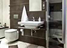 Aranżacje. W tej niewielkiej łazience wszystkie urządzenia sanitarne zainstalowano przy jednej ścianie, dzięki czemu na środku pozostało sporo wolnego miejsca. Starannie dobrane materiały wykończeniowe i kontrastowa kolorystyka sprawiają, że wnętrze wygląda bardzo elegancko. WNETRZA , LAZIENKA