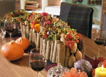 Kompozycje kwiatowe. Stroik w angielskim stylu. W otoczce z cynamonowej kory ozdobionej cedrowymi szyszkami - zwarta kompozycja z dalii, róż, aksamitek, krokosmii, owoców karczocha, róży, granatu, kaliny Kompozycje kwiatowe. Stroik w angielskim stylu. W otoczce z cynamonowej kory ozdobionej cedrowymi szyszkami - zwarta kompozycja z dalii, róż, aksamitek, krokosmii, owoców karczocha, róży, granatu, kaliny