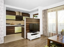 Salon. W otwartym wnętrzu panele położono tylko w części wypoczynkowej; w aneksie kuchennym są łatwe do utrzymania w czystości płytki ceramiczne. Miejsce styku tych dwóch różnych materiałów zostało zamaskowane listwą. WNETRZA , POKOJ , SALON , PODLOGA - PANELE LAMINOWANE