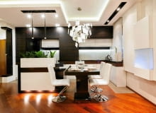 W głównym ciągu roboczym za taflami matowego szkła chroniącego ścianę między dolnymi a górnymi szafkami zamontowano taśmy LED; na blat przy oknie pada światło halogenów zainstalowanych w podwieszonym suficie. Nad niewielką wyspą zwieszają się lampy w kształcie sopli (Stylo firmy Azzardo). Funkcję czysto dekoracyjną pełnią natomiast halogeny ukryte w wyspie tuż nad podłogą. kuchnia, mebel kuchenne, oświetlenie w kuchni