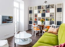 Otwarta strefa dzienna łączy salon i jadalnię. Tak jak w całym wnętrzu, tak i tu dominuje czysta biel. Ożywczy kolor wnosi kanapa z tapicerką w świeżym zielonym odcieniu. salon, wystrój wnętrz, mieszkanie, aranżacja wnętrz