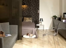 Sypialnia. Aneks sypialny, urządzony w pokoju dziennym, został wydzielony ze wspólnej przestrzeni dwuczęściową ścianką. Zrobiono ją z tzw. bezpiecznego szkła barwionego na ciemny kolor. WNETRZA SYPIALNIA SCIANKA DZIALOWA MEBLE