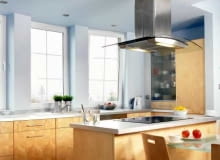 Ustawienie stołu przy wyspie to bardzo popularne rozwiązanie. Stół może być wolno stojący lub dołączony do wyspy, tworząc z nią jedną całość. W tej kuchni blat stołu znajduje się niżej niż blat roboczy.