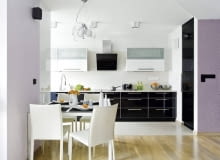 Fronty dolnych szafek kuchennych oraz drzwi wysokiej szafy-spiżarki są z czarnego szkła ujętego w aluminiowe ramki. Górne szafki, częściowo przeszklone, zrobiono z płyty MDF lakierowanej na wysoki połysk. Ze względów praktycznych podłogę przy ciągu roboczym wyłożono płytami gresu. Stół ustawiony na granicy kuchni i pokoju dziennego jest niewielki, ale po rozłożeniu może przy nim zasiąść aż osiem osób. Fronty dolnych szafek kuchennych oraz drzwi wysokiej szafy-spiżarki są z czarnego szkła ujętego w aluminiowe ramki. Górne szafki, częściowo przeszklone, zrobiono z płyty MDF lakierowanej na wysoki połysk. Ze względów praktycznych podłogę przy ciągu roboczym wyłożono płytami gresu. Stół ustawiony na granicy kuchni i pokoju dziennego jest niewielki, ale po rozłożeniu może przy nim zasiąść aż osiem osób.