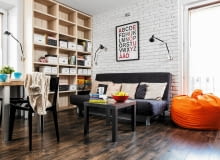 Funkcjonalnie i stylowo. Lekka kanapa z funkcją spania nie zajmuje dużo przestrzeni. Drewniany regał na całą ścianę zapewnia miejsce na przechowywanie. regały na książki