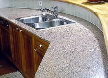 Blat kuchenny z odpornego na uderzenia, zaplamienia i wysoką temperaturę granitu (Baltic Brown) z krawędzią wykończoną półwałkiem. Zlewozmywak montowany od góry w otworze wyciętym z kamieniu.