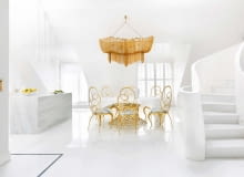 Jadalnia jest wyspą złotego ażuru na marmurowej tafli posadzki. Wokół unikatowego stołu Mondrian Art Form o podstawie ze złoconych metalowych krążków, krzesła Ghirigori (oba modele marki Cantori).