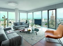 Meble i dodatki jak dzieła sztuki: charakterystyczna lampa podłogowa od Delightfull przypomina saksofon, skórzany fotel Lama projektu Ludowiki i Roberta Palombów dla Zanotta to już klasyk designu. Na podłodze dywan autorstwa Jana Katha. Kanapy od Rolf Benz, stoliki od Minotti.