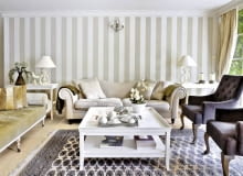 Ścianę pomalowano w szerokie szaro-beżowe pasy (podobny kolor mają obicia niektórych tapicerowanych mebli). Po obu stronach kanapy stoją stoliki pomocnicze; na nich wyeksponowano dekoracyjne przedmioty. Ścianę pomalowano w szerokie szaro-beżowe pasy (podobny kolor mają obicia niektórych tapicerowanych mebli). Po obu stronach kanapy stoją stoliki pomocnicze; na nich wyeksponowano dekoracyjne przedmioty.