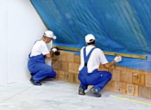 Układanie folii paroizolacyjnej. Należy przy tym zadbać o to, by szczelnie połączyć ją z innymi elementami konstrukcji domu - tu ze ścianą szczytową i kolankową