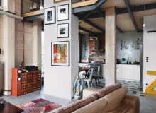 Przestrzeń salonu łączy się z kuchnią. Za okapem stary komin z odkrytą przedwojenną cegłą. Podkreśla nieco "chropowaty" charakter wnętrza. Na podłodze piękne gresowe płytki Hexagon (Zahna Fliesen). Komoda skomponowana z szufladek pochodzących ze starej fabryki wind. Madonna, to znaleziona figurka. vintage