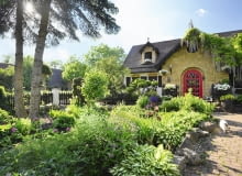 po lewej: Frontową ścianę domu zdobi imponująca glicynia. Przed wejściem dobudowano drewniany taras-ganek. po prawej: Domek na narzędzia - jego ściany nawiązują do tradycyjnego muru szachulcowego. po lewej: Frontową ścianę domu zdobi imponująca glicynia. Przed wejściem dobudowano drewniany taras-ganek. po prawej: Domek na narzędzia - jego ściany nawiązują do tradycyjnego muru szachulcowego.