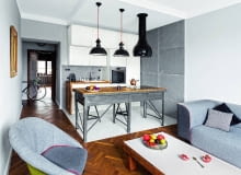 ANEKS KUCHENNY został optycznie wydzielony z przestrzeni dziennej innym kolorem podłogi. To taka sama dębowa klepka jak w pozostałej części pomieszczenia, tyle że pomalowana odporną na ścieranie farbą olejną. Nietypowa wyspa powstała ze stołu warsztatowego. Fragmenty ścian są pokryte betonowymi płytami. Zaimpregnowano je specjalnym preparatem, dzięki czemu nie chłoną plam.