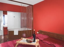 Aranżacje wnętrz. Sypialnia połączona z łazienką to dla niektórych wciąż ekstrawagancja, dla innych - wygodne rozwiązanie gwarantujące pełny relaks. Według nas, jeśli tylko warunki temu sprzyjają, warto zrealizować taki pomysł. Podobne zdanie mieli gospodarze prezentowanych wnętrz.<br/> Wannę z systemem hydromasażu zainstalowano niedaleko łóżka i umownie oddzielono zasłoną, będącą jednocześnie nietypową pachnącą dekoracją. Gospodarze własnoręcznie nawlekli na sznurki kawałki cynamonu, którego zapach umila zarówno kąpiel, jak i sen.