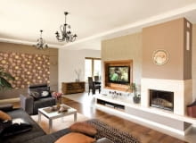 Aranżacje. Marzena i Jarek lubią swój dom z kilku powodów. Po pierwsze, przez okna salonu mogą oglądać sarny wychodzące na brzeg znajdującego się nieopodal lasu. Po drugie, wnętrza są bardzo przestronne i pełne światła. Po trzecie, dom jest parterowy, nie martwią się więc, że mała Zuzia i Jędrzej biegają po schodach.<BR />W salonie uwagę zwraca kącik telewizyjno-kominkowy. Obudowa kominka jest zrobiona z jasnego trawertynu. Płaski ekran, zawieszony we wnęce wykończonej palisandrem, wygląda jak obraz w ramie. Obraz przypomina również dekoracja w aneksie wypoczynkowym: obramowana płytą gipsowo-kartonową tapeta w kwiaty - motyw konsekwentnie powtarzający się we wszystkich pomieszczeniach. Aranżacje. Marzena i Jarek lubią swój dom z kilku powodów. Po pierwsze, przez okna salonu mogą oglądać sarny wychodzące na brzeg znajdującego się nieopodal lasu. Po drugie, wnętrza są bardzo przestronne i pełne światła. Po trzecie, dom jest parterowy, nie martwią się więc, że mała Zuzia i Jędrzej biegają po schodach.<BR />W salonie uwagę zwraca kącik telewizyjno-kominkowy. Obudowa kominka jest zrobiona z jasnego trawertynu. Płaski ekran, zawieszony we wnęce wykończonej palisandrem, wygląda jak obraz w ramie. Obraz przypomina również dekoracja w aneksie wypoczynkowym: obramowana płytą gipsowo-kartonową tapeta w kwiaty - motyw konsekwentnie powtarzający się we wszystkich pomieszczeniach.