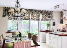 <B>Wydawałoby się, że lambrekin może tworzyć parę wyłącznie z tradycyjnymi, bogato drapowanymi zasłonami, a jego związek z nowoczesnymi roletami rzymskimi nie będzie równie udany. Otóż nie! Dowodem jest prezentowane wnętrze.</B> <BR />Rolą miękkiego lambrekinu jest zasłonięcie nadproża nad wnękami okiennymi i&#8200;optyczne podniesienie sufitu w&#8200;dość niskim pomieszczeniu. Jednocześnie jest on efektownym zwieńczeniem całej aranżacji okiennej -&#8200;uszytych&#8200;z tej samej tkaniny rzymskich rolet, które wiszą w&#8200;oknach i drzwiach balkonowych.