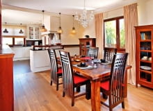 Aranżacje. Chociaż jadalnię od kuchni oddziela tylko blat-barek, nikt nie ma wątpliwości, że są to osobne pomieszczenia. Różni je i kolorystyka, i styl, i materiały, jakimi wykończono ściany oraz podłogę (w kuchni położono praktyczny gres, a w pozostałej części - deski). Jadalnia została umeblowana jak tradycyjny pokój stołowy; oprócz stołu z krzesłami stoją tu także kredensy i bufet. Zarówno te solidne drewniane sprzęty, jak i przedmioty dekoracyjne są utrzymane w stylu kolonialnym. Taki sam klimat panuje w salonie połączonym z jadalnią szerokim przejściem. Aranżacja kuchni nawiązuje natomiast do wystroju charakterystycznego dla domów z XIX-wiecznej angielskiej wsi, co podkreśla jej odrębność.<BR />Wystrój jadalni nie pozostawia wątpliwości, że nie jest ona tylko aneksem przy kuchni, ale samodzielnym wnętrzem. Granicę między kuchnią a jadalnią wyznacza blat-barek zrobiony na zamówienie z fornirowanej i bejcowanej płyty meblowej. W razie potrzeby można przy nim wypić kawę albo zjeść szybki posiłek. WNETRZA , JADALNIA . MEBLE