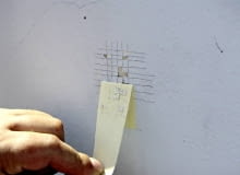 Test przyczepności farby. Im więcej kwadracików przyklei się do taśmy, tym gorsza przyczepność