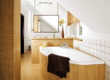 W UKRYCIU. Na pierwszy rzut oka ścianka wydzielająca bardziej intymną, kąpielową część pomieszczenia jest niemal niewidoczna. Nie dość, że idealnie wtapia się w tło, bo obłożono ją takimi samymi płytkami ceramicznymi jak podłogę, obudowę wanny i fragmenty ścian, to na dodatek od strony wejścia zasłaniają ją dwie szafki oraz zamontowana na jednej z nich spora umywalka. Chociaż płytki do złudzenia przypominają drewno, zapewniamy, że to jednak ceramika! Do wystroju wnętrza idealnie pasuje bambusowa roleta w oknie. W UKRYCIU. Na pierwszy rzut oka ścianka wydzielająca bardziej intymną, kąpielową część pomieszczenia jest niemal niewidoczna. Nie dość, że idealnie wtapia się w tło, bo obłożono ją takimi samymi płytkami ceramicznymi jak podłogę, obudowę wanny i fragmenty ścian, to na dodatek od strony wejścia zasłaniają ją dwie szafki oraz zamontowana na jednej z nich spora umywalka. Chociaż płytki do złudzenia przypominają drewno, zapewniamy, że to jednak ceramika! Do wystroju wnętrza idealnie pasuje bambusowa roleta w oknie.