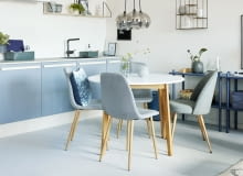 Krzesła przy stole jadalnianym w kolorze szafek kuchennych to dobry pomysł na harmonijną aranżację kuchni.