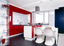 Kuchenna zabudowa z lakierowanej na czerwono płyty MDF zajmuje całą ścianę. Jasna wnęka w jej środku ma takie same wymiary jak kuchenna wyspa (można odnieść wrażenie, jakby wyspa po prostu została wyjęta z zabudowy). Blaty są zrobione z granitu. Na podłogę gospodyni początkowo wymarzyła sobie żywicę epoksydową, skończyło się na ciemnym gresie. UWAGA PONOWNA PUBLIKACJA ZA ZGODA WLASCICIELI