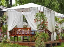 Zadaszony ogrodowy pawilon wsparty na metalowej konstrukcji daje cień ogrodowym biesiadnikom Zadaszony ogrodowy pawilon wsparty na metalowej konstrukcji daje cień ogrodowym biesiadnikom