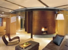 Otwarte na otoczenie pokoje zostały uzupełnione o wydzielone schowki oraz umieszczony centralnie walec z zapleczem sanitarnym. Pierścień korytarza to jednocześnie garderoba. Co ciekawe - od góry dostaje się tu naturalne światło! Wszystkie te przestrzenne zabiegi nie tylko uatrakcyjniają wnętrza, ale i dodają im funkcjonalności