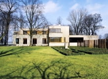 Rozłożysta bryła z wieloma tarasami została wykończona piaskowcem i drewnem Rozłożysta bryła z wieloma tarasami została wykończona piaskowcem i drewnem